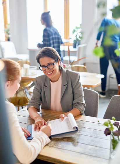 taking-applicant-vacancy A mature employer hands a contract to a young job applicant, inviting them to sign it during a professional meeting.